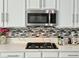 Modern kitchen with quartz countertops, tile backsplash, and stainless appliances at 5422 Nestled Moon Ct, Las Vegas, NV 89131