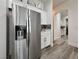 Modern kitchen features stainless steel refrigerator, white cabinets, and stylish backsplash at 5422 Nestled Moon Ct, Las Vegas, NV 89131