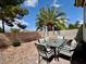 Cozy outdoor patio featuring a dining set and desert landscaping with a palm tree at 5422 Nestled Moon Ct, Las Vegas, NV 89131