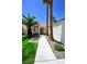 Inviting front entrance with a well-lit walkway, green lawn and desert landscaping at 5521 Desert Valley Dr, Las Vegas, NV 89149