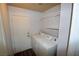 Functional laundry room features a washer and dryer, shelving, and exterior access at 5521 Desert Valley Dr, Las Vegas, NV 89149