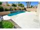 Private in-ground pool with rock waterfall feature surrounded by desert landscaping at 5521 Desert Valley Dr, Las Vegas, NV 89149