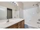 Well-lit bathroom with a tub, tiled walls, a wood vanity, and a large mirror at 5915 Nuevo Leon St # 8, North Las Vegas, NV 89031