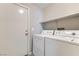 Laundry room equipped with washer, dryer, and shelving for storage at 5915 Nuevo Leon St # 8, North Las Vegas, NV 89031