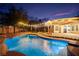 Inviting pool with a rock waterfall and string lights under the covered patio perfect for outdoor entertaining at 6907 May Basket Ave, Las Vegas, NV 89131