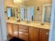 Bathroom featuring double sink vanity with white countertop, wood cabinets, and nautical themed decorations at 7020 Puetollano Dr, North Las Vegas, NV 89084