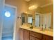 Bright bathroom features a well-lit shower/tub combo and a wooden vanity with white countertop at 7020 Puetollano Dr, North Las Vegas, NV 89084