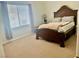 Bedroom with a large bed frame, carpet, and natural light from the window at 7020 Puetollano Dr, North Las Vegas, NV 89084