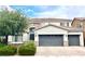 Two-story home featuring a tile roof, three-car garage, and manicured landscaping in a suburban neighborhood at 7020 Puetollano Dr, North Las Vegas, NV 89084