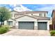 Two-story home featuring a tile roof, three-car garage, and manicured landscaping in a suburban neighborhood at 7020 Puetollano Dr, North Las Vegas, NV 89084