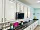 Bright kitchen featuring white cabinets, stainless steel appliances, black countertops, and a large island at 7020 Puetollano Dr, North Las Vegas, NV 89084