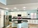 Bright kitchen featuring white cabinets, stainless steel appliances, black countertops, and a large island at 7020 Puetollano Dr, North Las Vegas, NV 89084