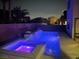 Backyard pool and spa at night, illuminated with colorful lights at 7020 Puetollano Dr, North Las Vegas, NV 89084