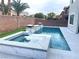 Backyard pool and spa area with white tile, artificial turf, and palm trees at 7020 Puetollano Dr, North Las Vegas, NV 89084