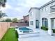 Backyard pool and spa featuring artificial grass, palm trees, and a two-story house at 7020 Puetollano Dr, North Las Vegas, NV 89084
