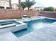Backyard pool and spa featuring decorative white tiled walls and modern landscaping at 7020 Puetollano Dr, North Las Vegas, NV 89084
