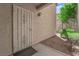 A condo unit's entrance with a security screen door, a door number, and a small landscape area at 7200 Pirates Cove Rd # 1011, Las Vegas, NV 89145