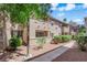 A two story condo building with desert landscaping featuring mulch and green bushes along a sidewalk at 7200 Pirates Cove Rd # 1011, Las Vegas, NV 89145