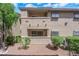 A two-story condo building with desert landscaping featuring green bushes and flowering pink plants at 7200 Pirates Cove Rd # 1011, Las Vegas, NV 89145