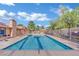 A community pool with clear blue water and lounge chairs next to a building with a stone chimney at 7200 Pirates Cove Rd # 1011, Las Vegas, NV 89145
