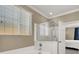 Bathroom with a frameless glass shower, soaking tub, and a view of the bedroom provides a serene and bright ambiance at 7428 Alamo Ranch Ave, Las Vegas, NV 89179