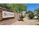 Community entrance with stone sign, manicured landscaping, and brick wall creating a welcoming atmosphere at 7428 Alamo Ranch Ave, Las Vegas, NV 89179