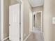 Neutral hallway featuring carpeted floors and open doors leading to various rooms within the home at 7428 Alamo Ranch Ave, Las Vegas, NV 89179