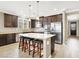 This kitchen features dark brown cabinets, stainless steel appliances, and an island with seating at 7428 Alamo Ranch Ave, Las Vegas, NV 89179