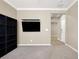 Spacious living room featuring carpet floors, a TV, and ample shelving for storage and display at 7428 Alamo Ranch Ave, Las Vegas, NV 89179