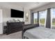 This spacious main bedroom features three large windows for natural light and a mounted TV at 7515 Emerald Stars St # 102, North Las Vegas, NV 89084