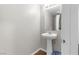 Compact powder room featuring a pedestal sink, mirror, and clean, neutral decor at 7515 Emerald Stars St # 102, North Las Vegas, NV 89084