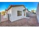A private backyard with gravel, a block wall, and a glimpse of the neighborhood at 7849 Montour Falls St, Las Vegas, NV 89149