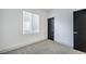 Bedroom featuring neutral carpet, white walls, a window with blinds, and a modern black door at 7849 Montour Falls St, Las Vegas, NV 89149