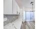 Stylish kitchen featuring quartz countertops, a modern backsplash, and sleek white cabinets at 7849 Montour Falls St, Las Vegas, NV 89149