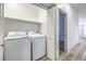 Laundry room featuring appliances, shelving, and a door to the hallway at 7849 Montour Falls St, Las Vegas, NV 89149