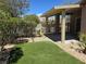 Backyard featuring an artificial turf area, rock landscaping, and a covered patio at 7957 Fantail Dr, North Las Vegas, NV 89084