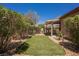 Secluded backyard featuring a synthetic grass area and mature shrubs, creating a serene outdoor space at 7957 Fantail Dr, North Las Vegas, NV 89084