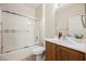 Bathroom featuring a wood vanity with a single sink and a shower-tub combo at 7957 Fantail Dr, North Las Vegas, NV 89084