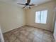An inviting bedroom features neutral walls, tile flooring and a modern ceiling fan at 7957 Fantail Dr, North Las Vegas, NV 89084