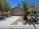 Charming single-story home featuring a two-car garage, desert landscaping, and a large palm tree at 7957 Fantail Dr, North Las Vegas, NV 89084