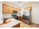 Well-lit kitchen features stainless steel appliances, white countertops, mosaic tile backsplash, and wood cabinets at 7957 Fantail Dr, North Las Vegas, NV 89084
