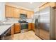 Spacious kitchen with stainless steel appliances, wood cabinets, and tile flooring at 7957 Fantail Dr, North Las Vegas, NV 89084