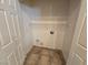 A compact laundry room features tile flooring and convenient storage shelving at 7957 Fantail Dr, North Las Vegas, NV 89084