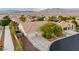 Aerial view of home with desert landscaping, spacious driveway, three-car garage, and partial mountain views at 8356 Shady Lady Ct, Las Vegas, NV 89131