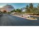 Community entrance sign with manicured landscaping, trees, and a view of homes in the background at 8356 Shady Lady Ct, Las Vegas, NV 89131