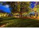 Expansive backyard with mature trees, lush lawn, and beautiful mountain views creates a tranquil outdoor oasis at 853 Morning Sun Ct, Las Vegas, NV 89110