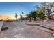 Desert landscape featuring a firepit, desert foliage, and stone pathways. The property is surrounded by palm trees at 853 Morning Sun Ct, Las Vegas, NV 89110