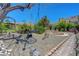 Backyard featuring a swing, gravel walkway, and stone pavers, complemented by mature desert landscaping at 853 Morning Sun Ct, Las Vegas, NV 89110