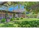 Backyard oasis with lush lawn, covered patio, and mature trees, perfect for outdoor relaxation and entertaining at 853 Morning Sun Ct, Las Vegas, NV 89110