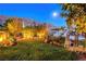 Lush backyard with well-manicured lawn, garden, mountain views, and landscape lighting at 853 Morning Sun Ct, Las Vegas, NV 89110